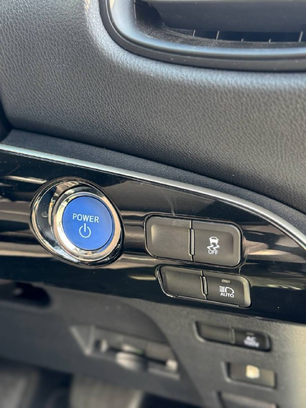 Кнопка запуска Power и блок управления вспомогательных функций в салоне Toyota Prius — крупный план с видимыми кнопками.