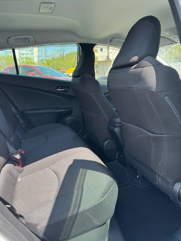 Задний ряд салона Toyota Prius: два ряда сидений, запас пространства для ног и состояние ткани обивки на фоне потолка и боковин.