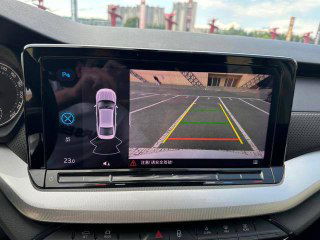 Экран мультимедиа Skoda Octavia с изображением камеры заднего вида и разметкой парковки; демонстрация ассистентов и визуального контроля при маневрах.