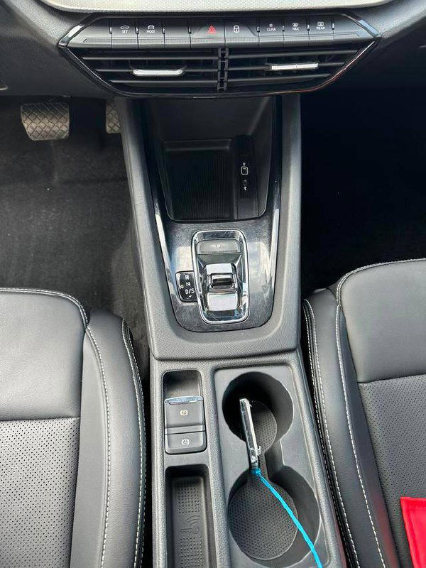 Нижняя часть центральной консоли Skoda Octavia, селектор передач и подстаканник в салоне; фото показывает уровень износа и доступность розеток/разъемов.