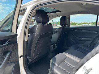 Задние сиденья Skoda Octavia, пространство для пассажиров и состояние обивки на фоне открытой задней двери; фото полезно для оценки пространства салона.