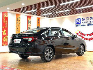 Задняя и боковая часть черного Honda Crider в салоне — показаны линии кузова, колеса и задние фонари на фоне рекламных плакатов дилера.