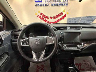 Рулевое колесо Honda Crider и центральная консоль — крупный план на кнопки управления, качественная отделка и вид на лобовое стекло с баннерами салона.