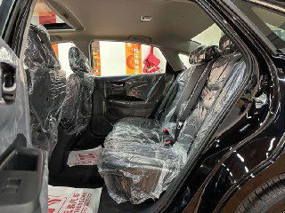 Задний ряд сидений Honda Crider с защитной плёнкой; видно пространство для ног и конфигурацию подголовников в салоне автомобиля.