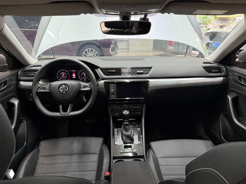 Интерьер Skoda Superb: панель приборов, руль, центральная консоль и сиденья — общий вид приборной панели и мультимедиа.