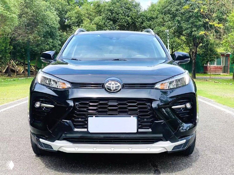 Toyota Wildlander чёрного цвета: передний вид автомобиля на дороге, выраженная лицевая часть и решётка радиатора в кадре.