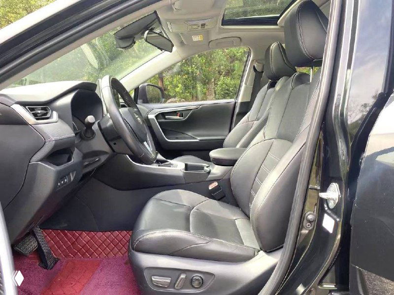 Интерьер Toyota Wildlander: передние сиденья и панель, чёрная кожаная отделка и руль, общий вид салона и компоновки.