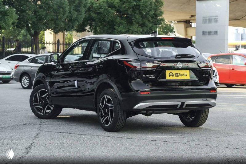 Чёрный Nissan Qashqai 2025, задний ракурс на стоянке, видны задние фонари, бампер и общий силуэт автомобиля на фоне дилерского центра.