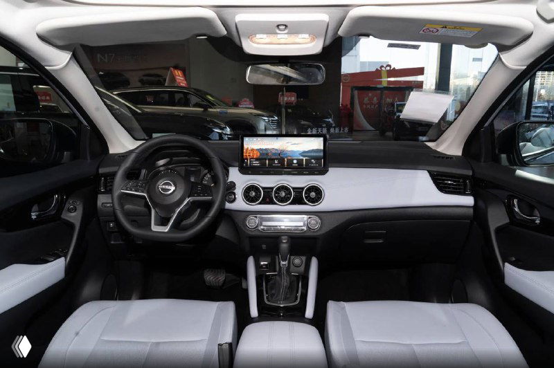 Интерьер Nissan Qashqai 2025 — общий вид торпедо и центральной консоли, большой экран мультимедиа и светлая отделка сидений.