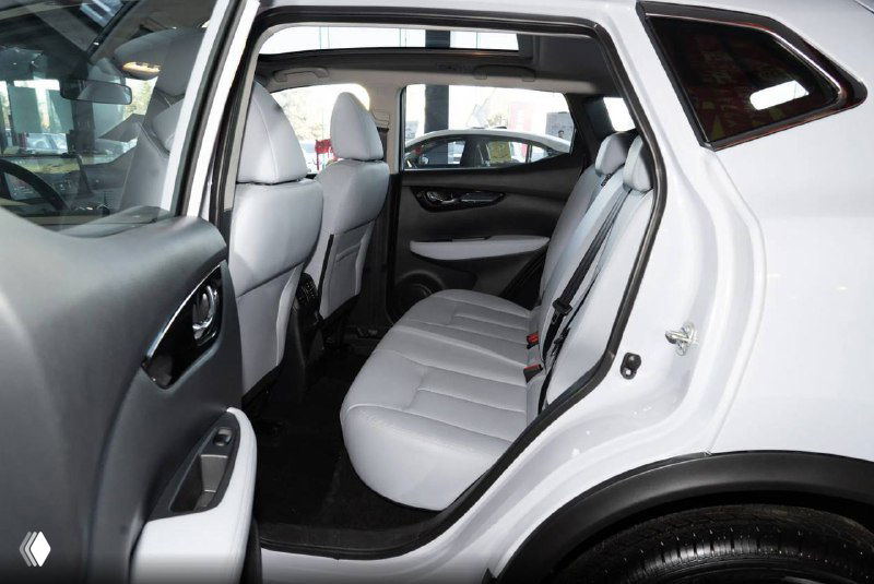 Задний ряд сидений Nissan Qashqai 2025, светлая обивка, комфортное пространство для пассажиров и вид дверной панели с ручками.