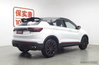 Белый Geely Coolray, задняя трёхчетвертная проекция; видны элементы диффузора и двойные патрубки выхлопа, автомобиль на демонстрационной площадке.