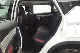 Задние сиденья Geely Coolray, вид через открытую заднюю дверь; показаны три посадочных места, материалы обивки и пространство для ног.