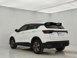 Белый GEELY COOLRAY 2022 — вид сзади и в три четверти в студийных условиях, видны задний бампер, двойные патрубки и задние фонари.