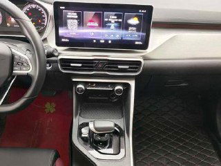 Крупный план центральной консоли GEELY COOLRAY: селектор коробки РКПП, элементы управления климатом и сенсорный дисплей мультимедиа.