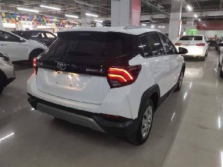 Вид сзади белого Toyota Yaris L 2022 в автосалоне, видна форма задних фонарей и бампер, фото для проверки задней части кузова и светотехники.