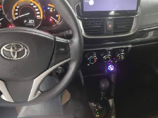 Салон Toyota Yaris L 2022 — панель приборов, мультимедийный экран и рулевое колесо, фото для оценки состояния интерьера и электроники автомобиля.