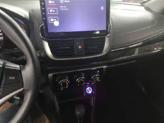 Центральная консоль Toyota Yaris L 2022 — крупный план рычага коробки передач и органов управления климатом, чистая отделка и функциональные элементы.