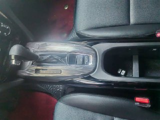 Крупный план центральной консоли Honda XR-V: селектор вариатора, отделение для мелочей и комбинированная отделка между передними сиденьями в салоне.