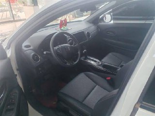 Вид передней пассажирской зоны Honda XR-V: салонные сиденья, открытая дверь, центральный туннель и общая компоновка интерьера в дилерском зале.