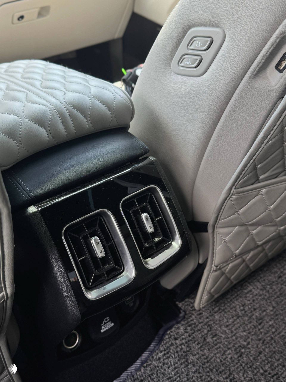 Воздушные дефлекторы и панель управления на задней части центрального тоннеля KIA Sorento, крупный план воздуховодов и розеток.