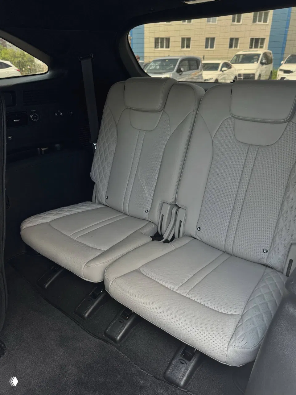 Третий ряд сидений KIA Sorento в светлой обивке, два раздельных сиденья с подголовниками, вид из салона на заднюю часть автомобиля.