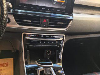 Крупный план центральной консоли KIA KX3: мультимедийный экран, блок управления климатом и селектор передач в современном оформлении