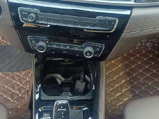 Центральная консоль BMW X1 xDrive 25Li — селектор коробки передач, органы управления климатом, подстаканники и декоративные вставки в салоне.