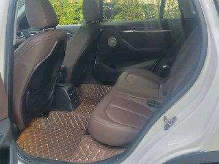 Задний ряд сидений BMW X1 xDrive 25Li — коричневые сиденья, место для двух пассажиров и пространство багажного отсека видно через салон.