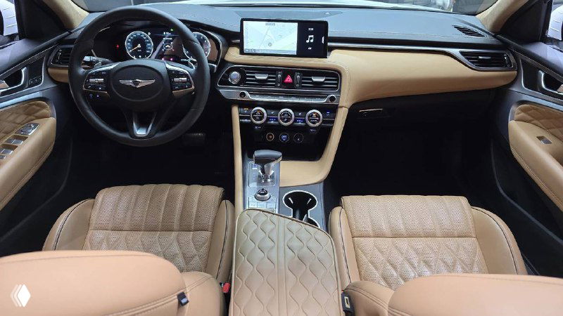 Салон Genesis G70: бежевые кожаные сиденья с прострочкой, рулевое колесо и центральная консоль, общий вид салона автомобиля.