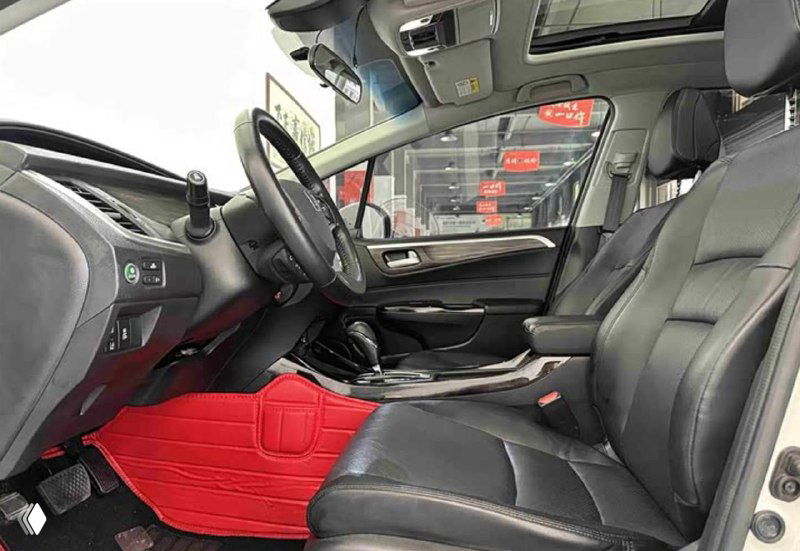 Передние сиденья Honda Jade с кожаной обивкой, водительское место с красными напольными ковриками, рукояти и элементы управления видны крупным планом.