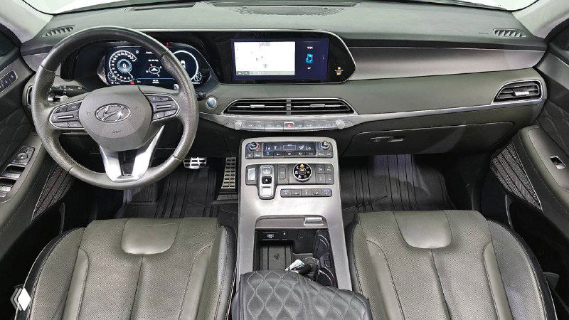 Фото салона Hyundai Palisade: передняя панель, рулевое колесо и центральный дисплей; видны материалы отделки и приборы.