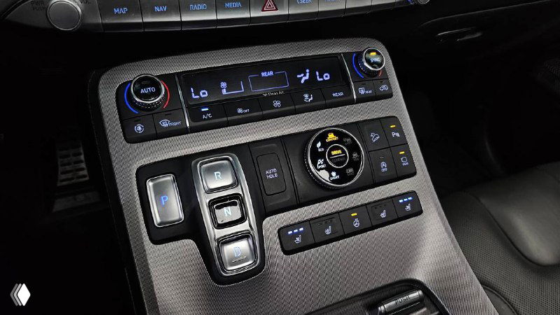 Крупный план центральной консоли Hyundai Palisade с элементами управления климатом, селектором передач и декоративными вставками интерьера.