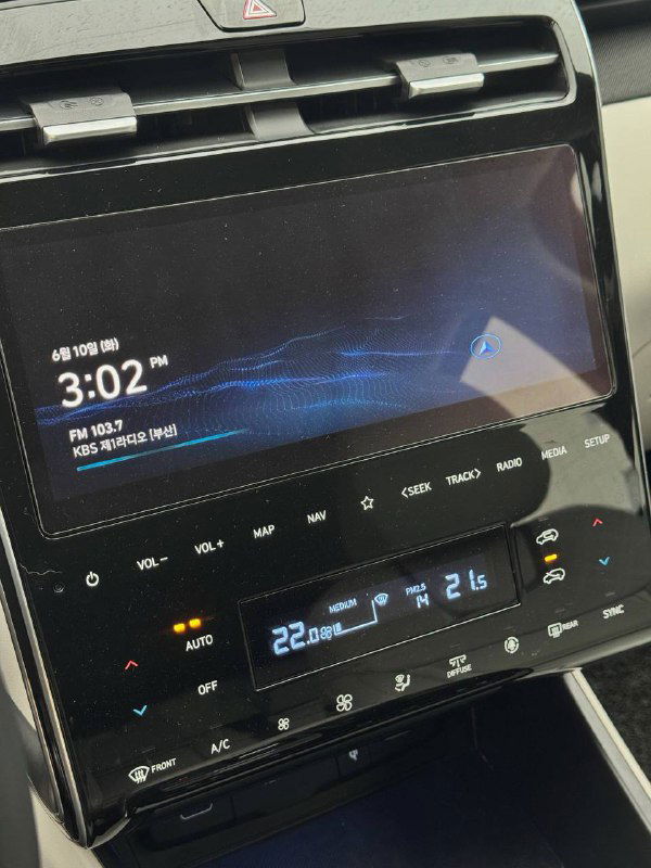 Крупный план мультимедийного экрана и панели управления климатом в Hyundai Tucson: сенсорный дисплей, информативная графика и блок климат-контроля.