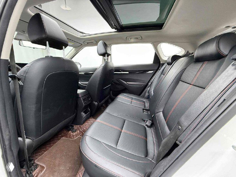 Задний ряд сидений KIA KX3: трёхместный диван в той же отделке, видна достаточная нога и общий простор салона.