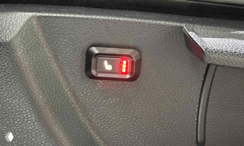 Крупный план индикатора подогрева сиденья с красной подсветкой, демонстрирующий наличие функции подогрева в комплектации.