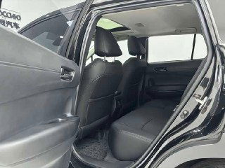 Открытая задняя правая дверь Toyota Corolla Cross, вид на задние сиденья и пространство для пассажиров — чёрная обшивка и чистое состояние.