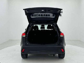 Багажное отделение Toyota Corolla Cross с открытой крышкой — пространство багажника видно в светлой студии, чистая погрузочная зона.