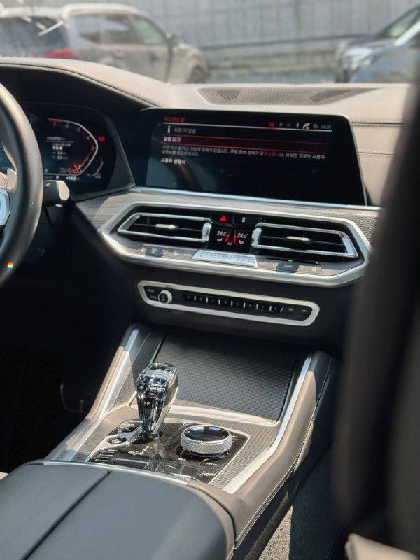 Центральная консоль BMW X6 с экраном мультимедиа и климат‑панелью — детализация салона и состояние панели управления