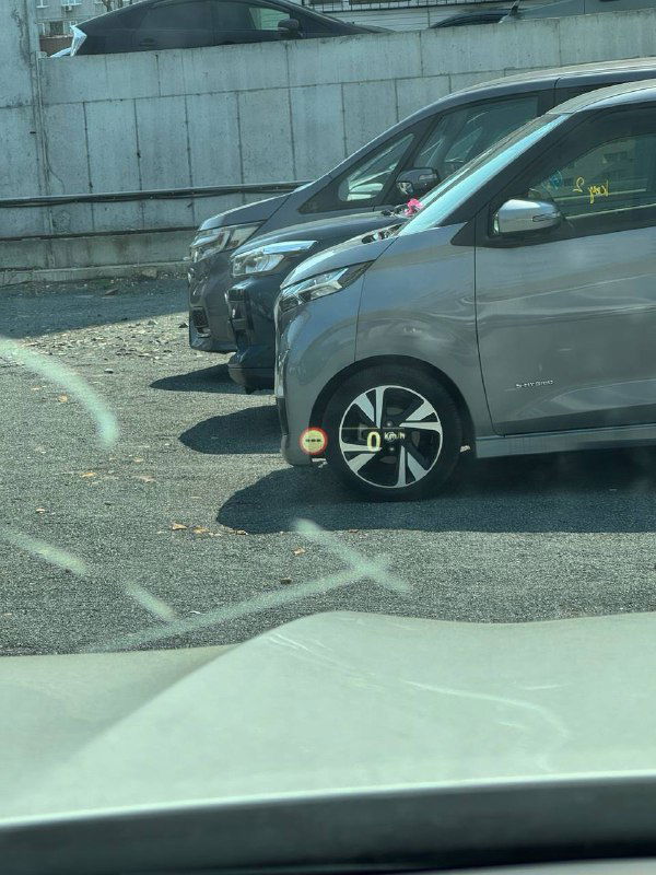 Парковка рядом с BMW X6 — вид через стекло на соседние автомобили и городскую стоянку, контекст местонахождения машины