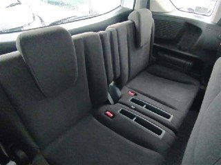 Фрагмент салона Honda Freed 2014: третий ряд сидений или откидные сиденья с текстильной обивкой и видимыми креплениями, чистое состояние поверхности.