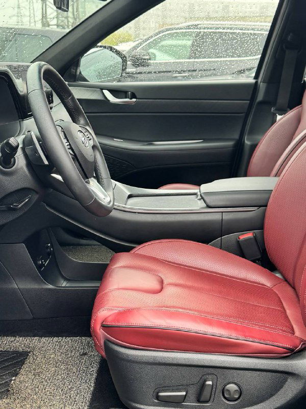 Фотография переднего пассажирского места и водительской зоны Hyundai Palisade — видно красную кожаную отделку сидений и центральный подлокотник.