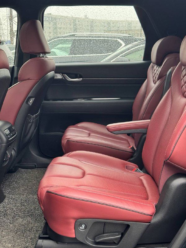 Задние кресла Hyundai Palisade в красной кожаной отделке, показаны комфортные сиденья второго ряда и простор салона для пассажиров.