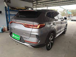 Боковой и задний ракурс серого Song Plus New на стоянке: подчеркнуты фонари, линия кузова, задний бампер и стильные колёсные диски на фоне автостоянки.