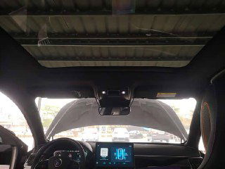 Вид из салона вверх на панорамную область крыши и стойки лобового стекла: камера и сенсорный модуль над зеркалом, обзор вперёд и часть торпедо.