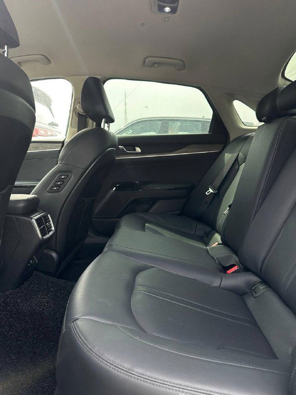 Задний ряд сидений KIA K5: кожаная обивка, запас пространства для ног, подголовники и вентиляционные дефлекторы — демонстрация места для пассажиров.