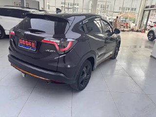 Корма и боковая часть Honda Vezel 2022 в шоуруме: светодиодные фонари, эмблема Vezel и аккуратная окраска кузова на фоне других авто.