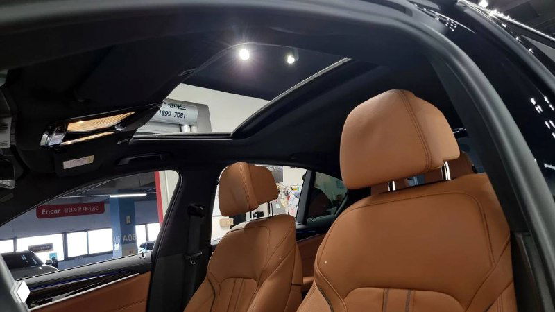 Панорамный люк BMW 520i, вид на стеклянный люк и обивку потолка салона, демонстрация естественного освещения и внутренней отделки.