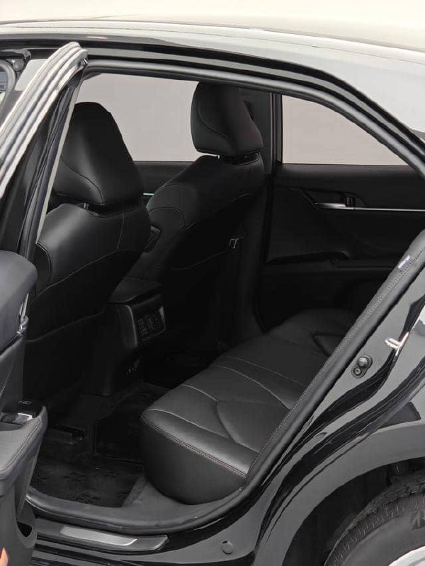 Вид заднего пассажирского сиденья Toyota Camry 2020: показаны подголовники, обивка и пространство для ног, фотография для оценки состояния салона и удобства.