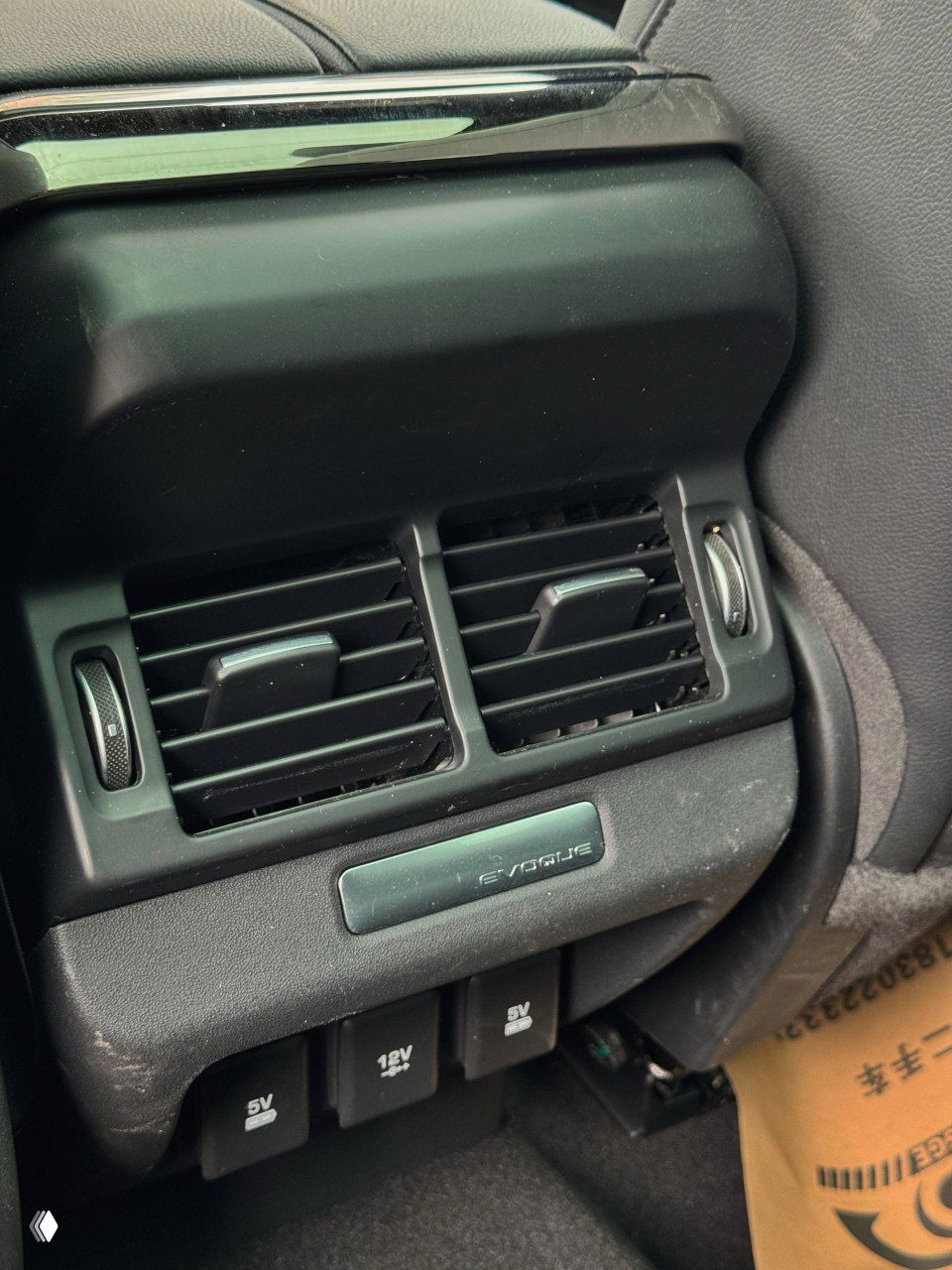Задний ряд сидений Range Rover Evoque: кожаная обивка, воздуховоды в центральной консоли и розетки для задних пассажиров, место для ног видно.
