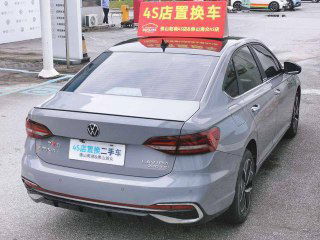 Вид сзади на серый Volkswagen Lavida: кормовая часть, задние фонари, бампер и китайская номерная табличка дилера на парковке.